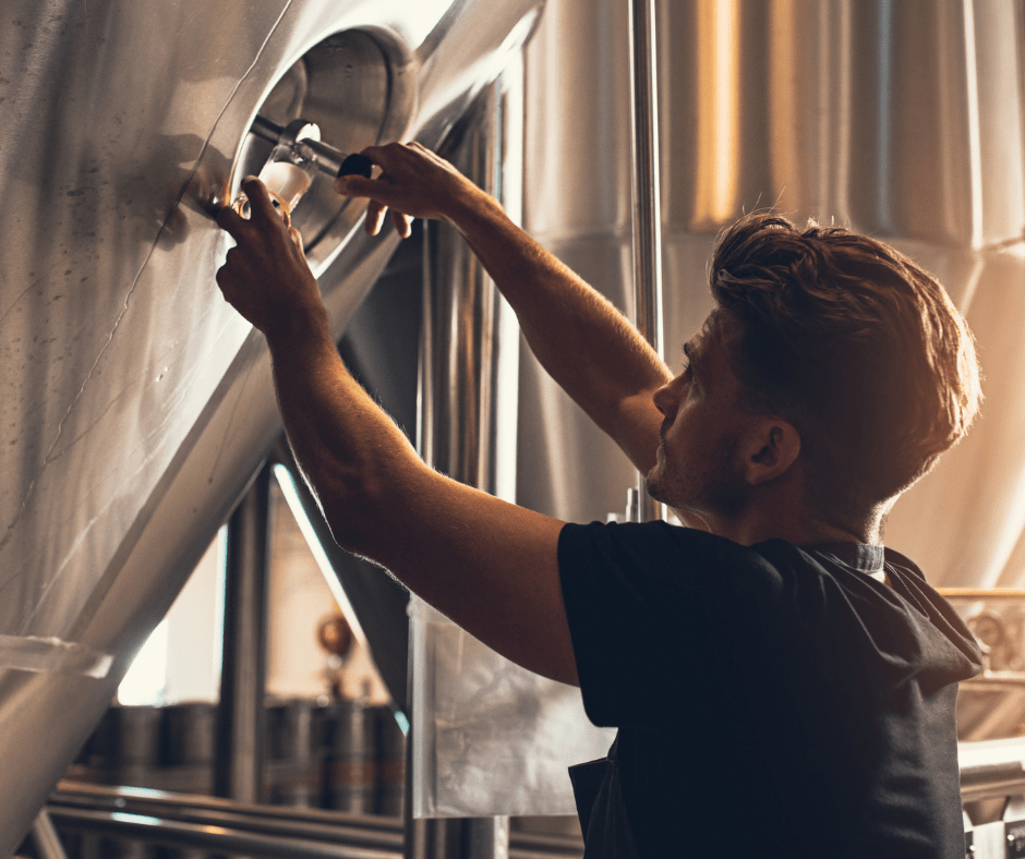 A Man who is testing beer from a brewery. 